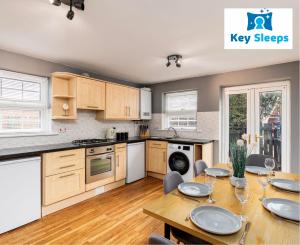 a kitchen with a wooden table and a dining room at Key Sleeps- Spacious - Contractor House - Central Location - Garden - Lincolnshire in Lincolnshire
