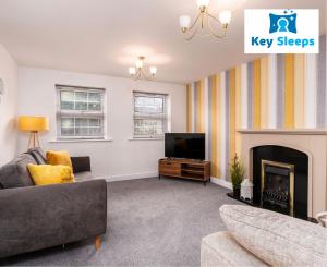 uma sala de estar com um sofá, uma televisão e uma lareira em Key Sleeps- Spacious - Contractor House - Central Location - Garden - Lincolnshire em Lincolnshire