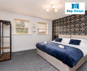 1 dormitorio con 1 cama extragrande con sábanas azules en Key Sleeps- Spacious - Contractor House - Central Location - Garden - Lincolnshire en Lincolnshire