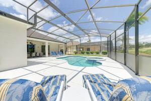 a patio with chairs and a swimming pool at 596 Modern 5 bed home overlooking beautiful golf course and conservation with Games room in Davenport
