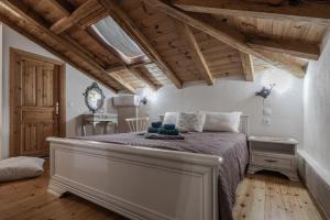 a bedroom with a large bed in a room with wooden ceilings at Orpheus and Eurydice Boutique Apartments in Skiathos