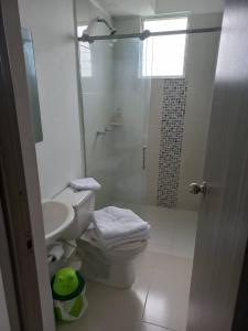 y baño con ducha, aseo y lavamanos. en Apartamento hogareño, en Pereira