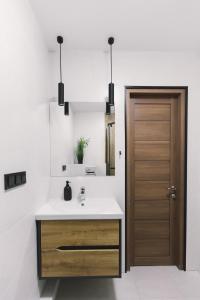 baño con lavabo y puerta de madera en Нова квартира з неймовірним краєвидом на озеро, en Kiev