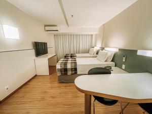 ein Hotelzimmer mit 2 Betten und einem Tisch in der Unterkunft St Paul Plaza Hotel in Brasilia