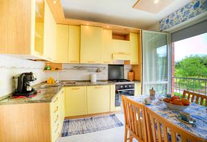 een keuken met gele kasten en een tafel met een fruitschaal bij Roger's Apartment in Siena