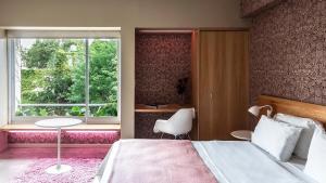 a bedroom with a bed and a table and a window at Home Hotel in Buenos Aires