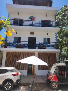 a white building with a golf cart and an umbrella at DownTown Rooms San Pancho in San Francisco