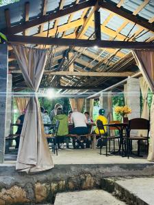 a group of people sitting at tables in a pavilion at Martvili canyon cottage in Gachedili