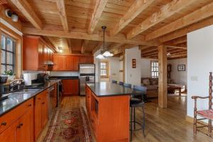 een grote keuken met houten kasten en een woonkamer bij Dug's House in Stowe