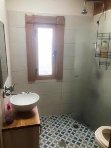 La salle de bains est pourvue d'un lavabo et d'une douche. dans l'établissement Ananda, à Hararit