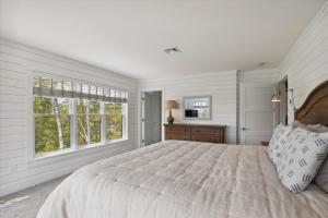 a white bedroom with a large bed and a window at Francis Lane in Stowe