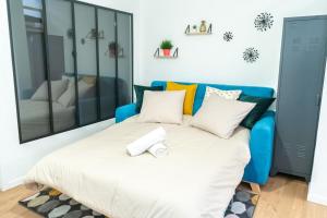 Cama en habitación con sofá azul en Le TANNEURS-charmant 6 pers-Pieds du métro Valmy, en Lyon