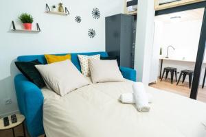 1 dormitorio con 1 cama blanca y 1 sofá azul en Le TANNEURS-charmant 6 pers-Pieds du métro Valmy, en Lyon