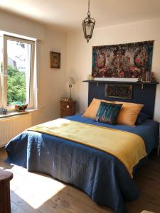 ein Schlafzimmer mit einem blauen Bett und einem Gemälde an der Wand in der Unterkunft VILLA EVA in Bray-Dunes