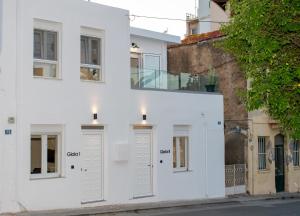 a white building with white doors on a street at Gioia I & Gioia II in Rethymno