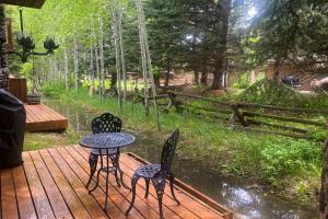 três cadeiras e uma mesa num deque de madeira em Camp Cottonwood em Teton Village