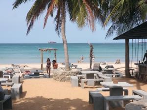 - une plage avec des tables et des chaises et l'océan dans l'établissement BEACH LIFE UPPUVELI, à Trincomalee