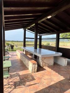a picnic table on a patio with a view of the ocean at Agriturismo Graziano e Barbara in Porto Conte