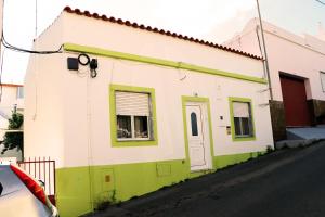 un pequeño edificio blanco y verde con ventana en Urban Beach - A Algarvia en Portimão
