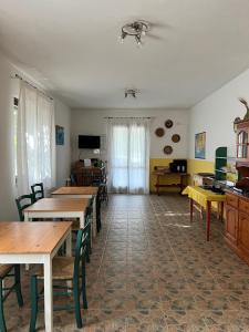 Habitación con mesas y sillas de madera y cocina. en Agriturismo Graziano e Barbara en Porto Conte