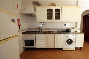 uma cozinha com armários brancos e uma máquina de lavar roupa em Urban Beach - A Algarvia em Portimão