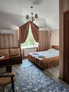 ein Schlafzimmer mit einem Bett, einem Sofa und einem Fenster in der Unterkunft Вiлла Тераса in Poljana