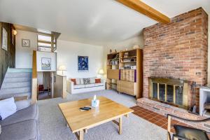 a living room with a fireplace and a brick wall at Notchbrook 28AB in Stowe