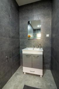 a bathroom with a sink and a mirror at City Gate Apartment in Ohrid +29 photos
