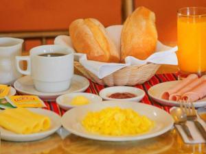- une table avec des assiettes de nourriture et des tasses de café et de pain dans l'établissement R&N SHULLKAS SUITES, à Huancayo