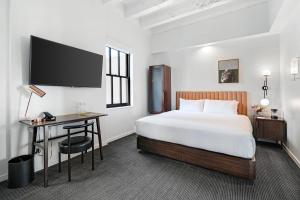 a hotel room with a bed and a desk and a tv at The Guild Hotel, San Diego, a Tribute Portfolio Hotel in San Diego