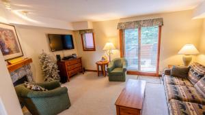 a living room with a couch and chairs and a fireplace at Timberline Village #38 By Bear Country in Sun Peaks