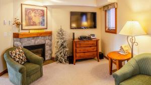 a living room with two chairs and a fireplace at Timberline Village #38 By Bear Country in Sun Peaks