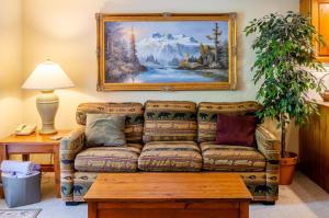 a living room with a couch and a painting on the wall at Timberline Village #38 By Bear Country in Sun Peaks