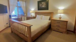 a bedroom with a bed and a nightstand and a window at Settlers Crossing #29 By Bear Country in Sun Peaks