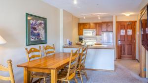 a kitchen with a wooden table and chairs in a room at Fireside Lodge #315 By Bear Country in Sun Peaks