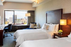 a hotel room with two beds and a desk and a window at Renaissance Seattle Hotel in Seattle