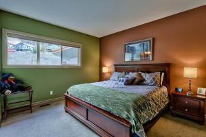a bedroom with a bed with green walls and a window at Soleil Chalet in Sun Peaks +24 photos