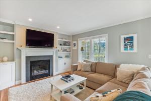 a living room with a couch and a fireplace at Village Sunrise in Stowe