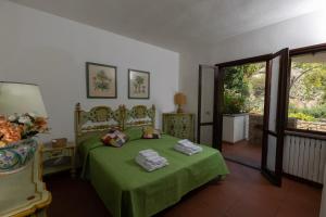 a bedroom with a green bed with towels on it at * * * Cypress Villa * * * {Free Parking} in Giglio Porto