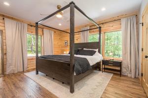 ein Schlafzimmer mit einem Himmelbett in einem Zimmer mit Holzwänden in der Unterkunft Camp Anawanna in McHenry
