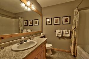 a bathroom with a sink and a toilet and a mirror at Crystal Forest #40 By Bear Country in Sun Peaks