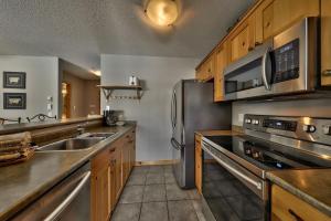 a kitchen with stainless steel appliances and wooden cabinets at Crystal Forest #40 By Bear Country in Sun Peaks