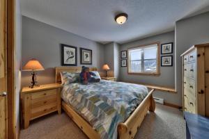 a boy sitting on a bed in a bedroom at Crystal Forest #40 By Bear Country in Sun Peaks +16 photos