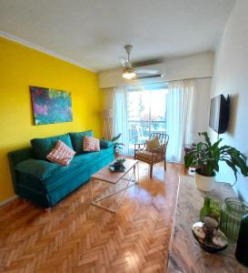 sala de estar con sofá verde y paredes amarillas en Boho style con balcón en Palermo Soho en Buenos Aires