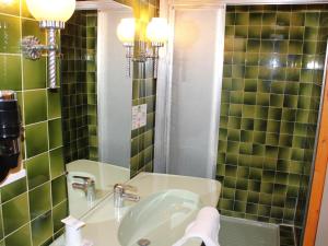 La salle de bains est pourvue d'un lavabo et d'un miroir. dans l'établissement Hotel Du Gave, à Lourdes