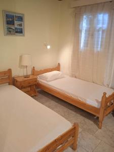 two twin beds in a room with a window at Peyko Rooms in Keri