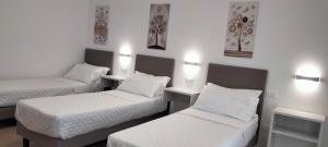 twee bedden in een kamer met witte muren bij THE BEST SUITES & ROOMS - A pochi passi dalla kasbah - in Mazara del Vallo