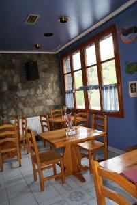 a dining room with wooden tables and chairs at Hostal Los Valles in Bielsa