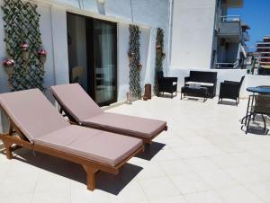 two lounge chairs and a table on a patio at Lilian's Seaview-Barstreet-Youth Studios in Rhodes Town