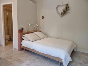 1 cama en un dormitorio con un corazón en la pared en Le Mazet, gîte des Lucioles en Provence, en Montségur-sur-Lauzon